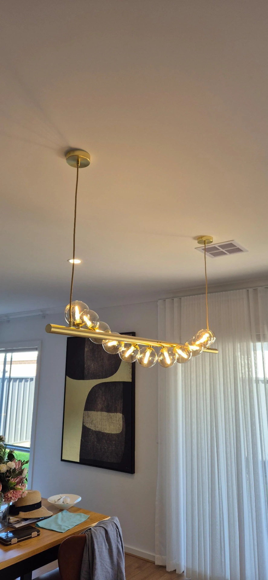 Brass linear globe pendant over a dining table