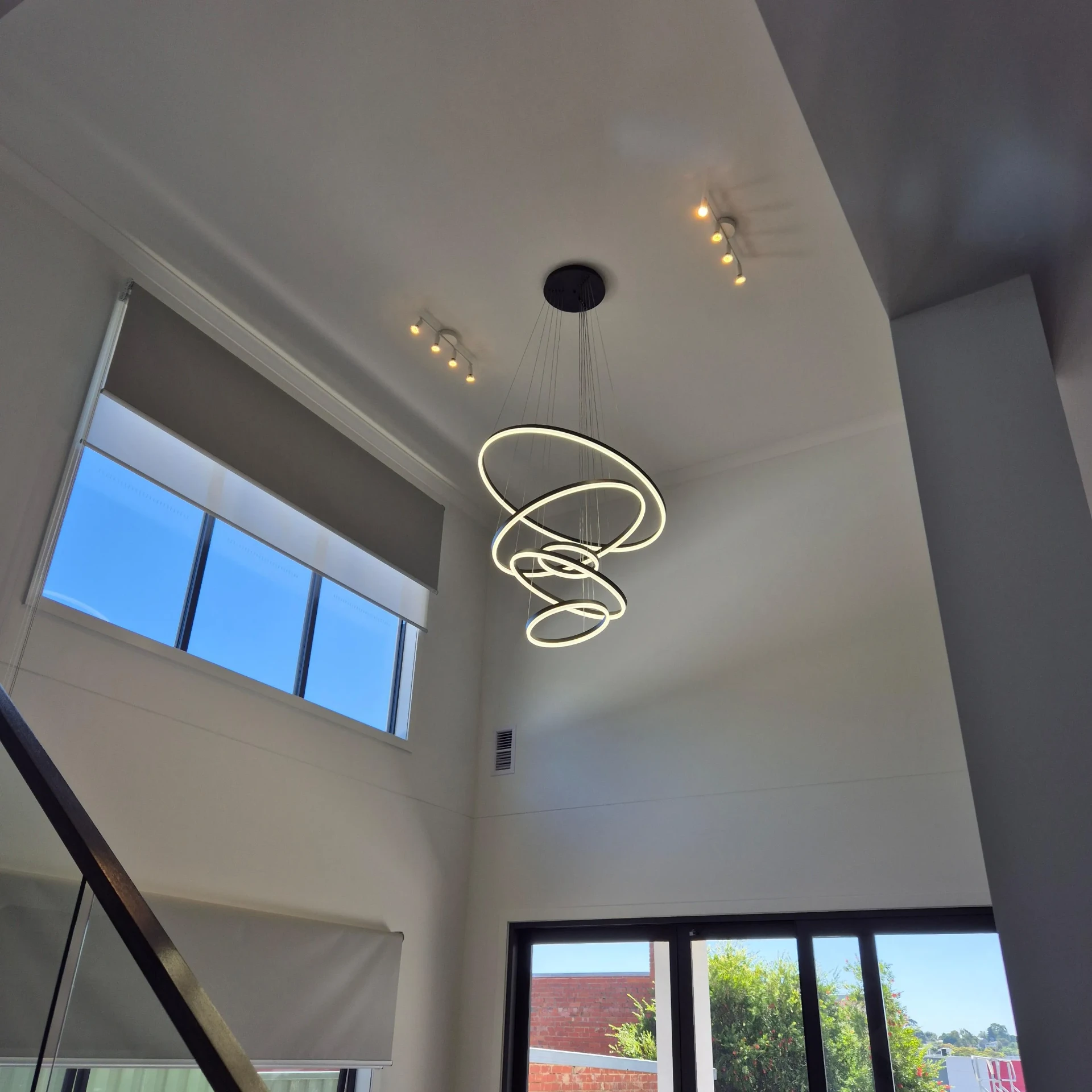 Multi-ring LED chandelier in double-height entry void