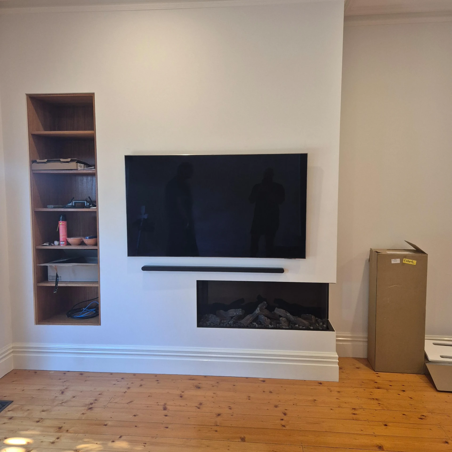 Wall-mounted TV and soundbar over a built-in fireplace feature wall
